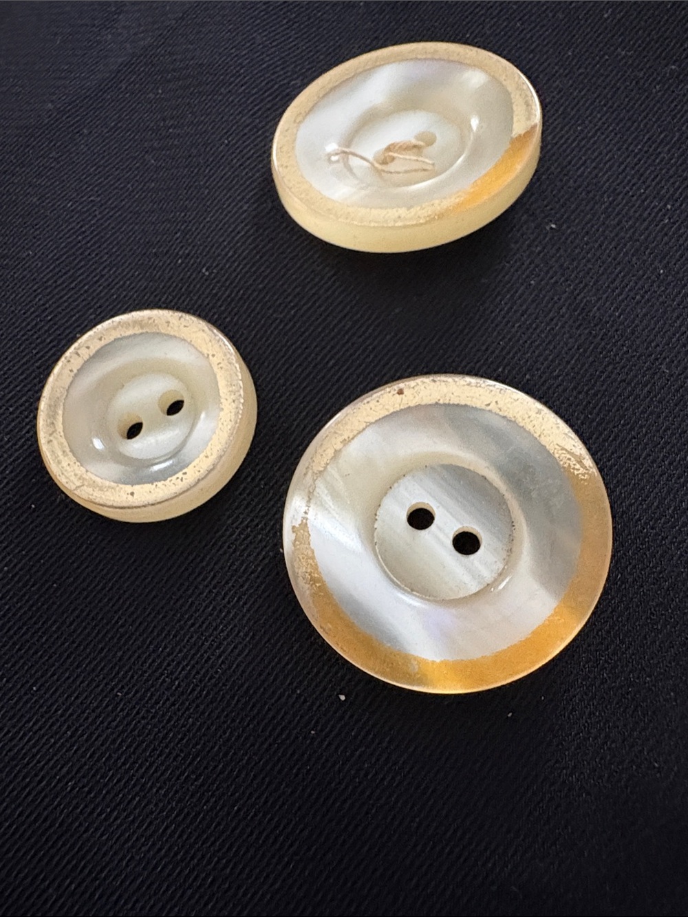 Three mother of Pearls buttons, trimmed and gold